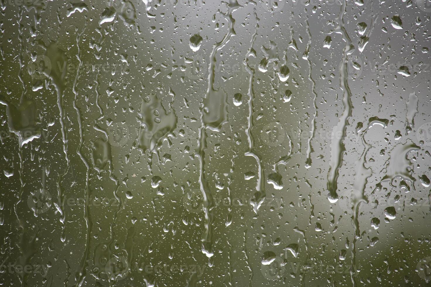 Raindrops on a window create a beautiful, natural pattern with blurred, abstract textures. photo