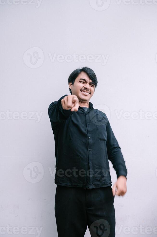 Enthusiastic man pointing towards camera with joyful expression photo