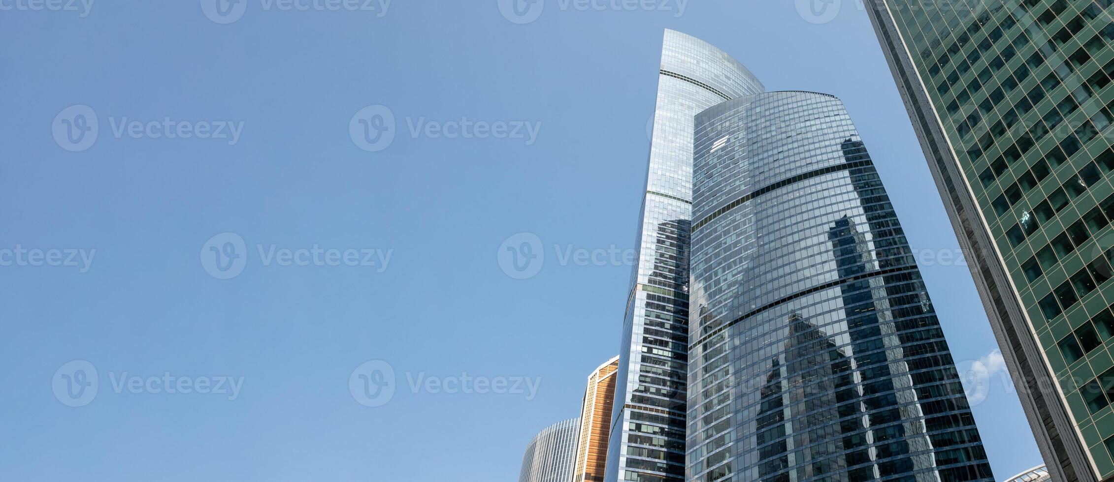 Modern Skyscrapers Reflect Sunlight Against a Clear Blue Sky in Moscows Bustling Cityscape photo