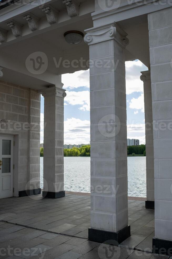 Beautiful Riverside View Through Elegant Columns at a Pavilion on a Sunny Day, Showcasing Nature and Architecture Harmoniously photo