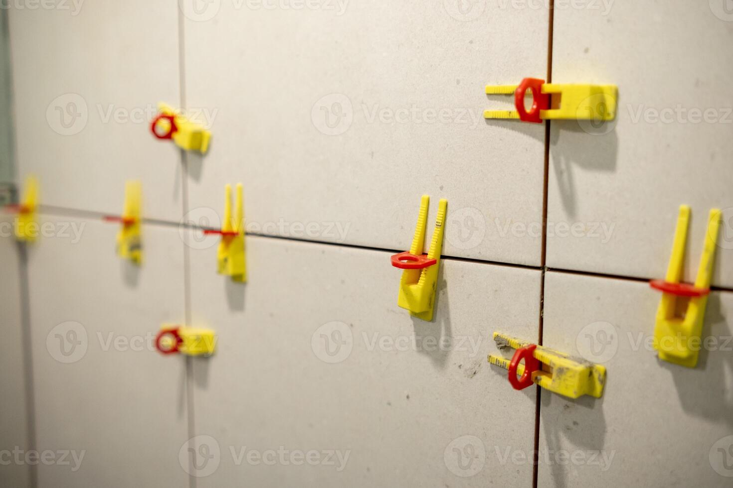 Tools and Materials Used for Tile Installation Displayed on a Wall in a Construction Site During the Day photo