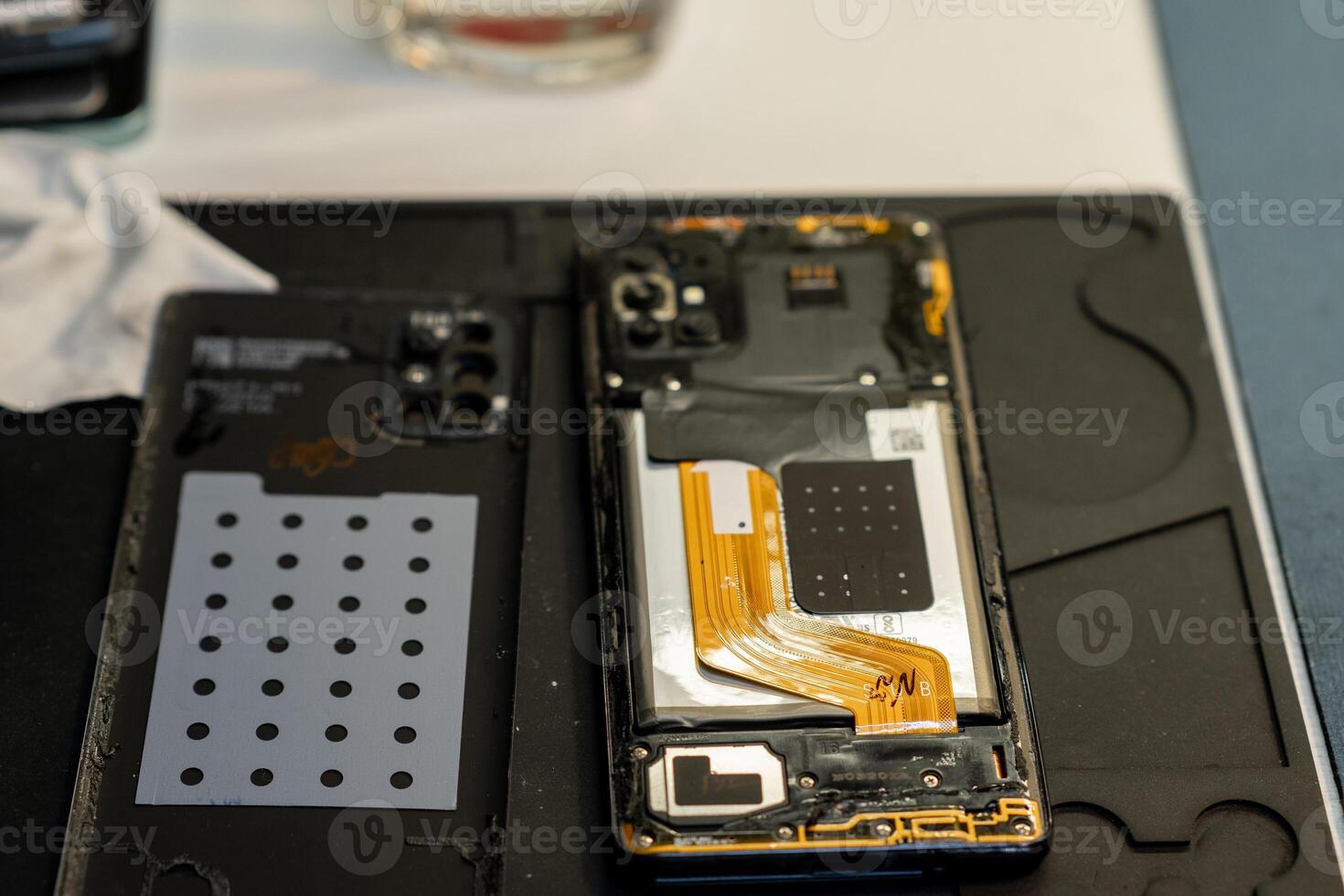 Expert Phone Repair Process With Open Smartphone, Tools, and Components at a Local Repair Shop During the Day photo