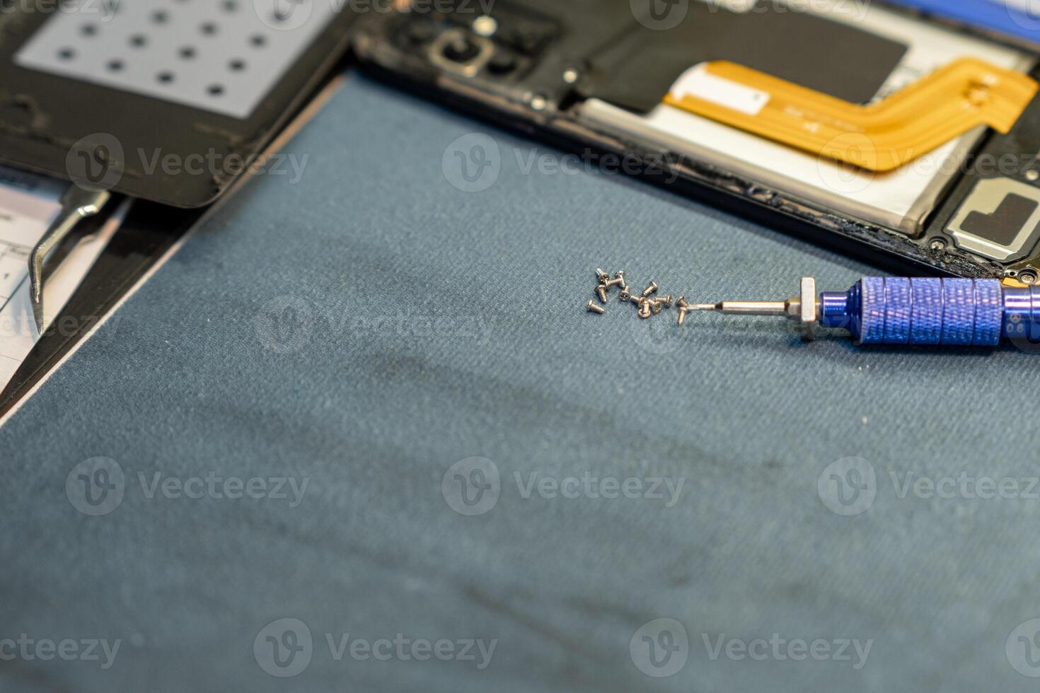 Expert Phone Repair Technician Working on Device Components in a Repair Shop During the Day photo