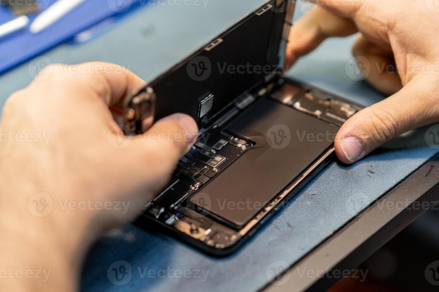 Expert Technician Repairing Smartphone Battery in Modern Workshop Environment photo