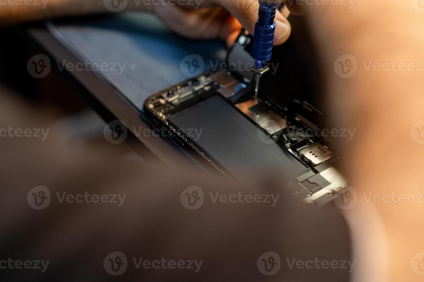 Expert Performs Phone Repair With Precision Tools at a Workshop During the Day photo