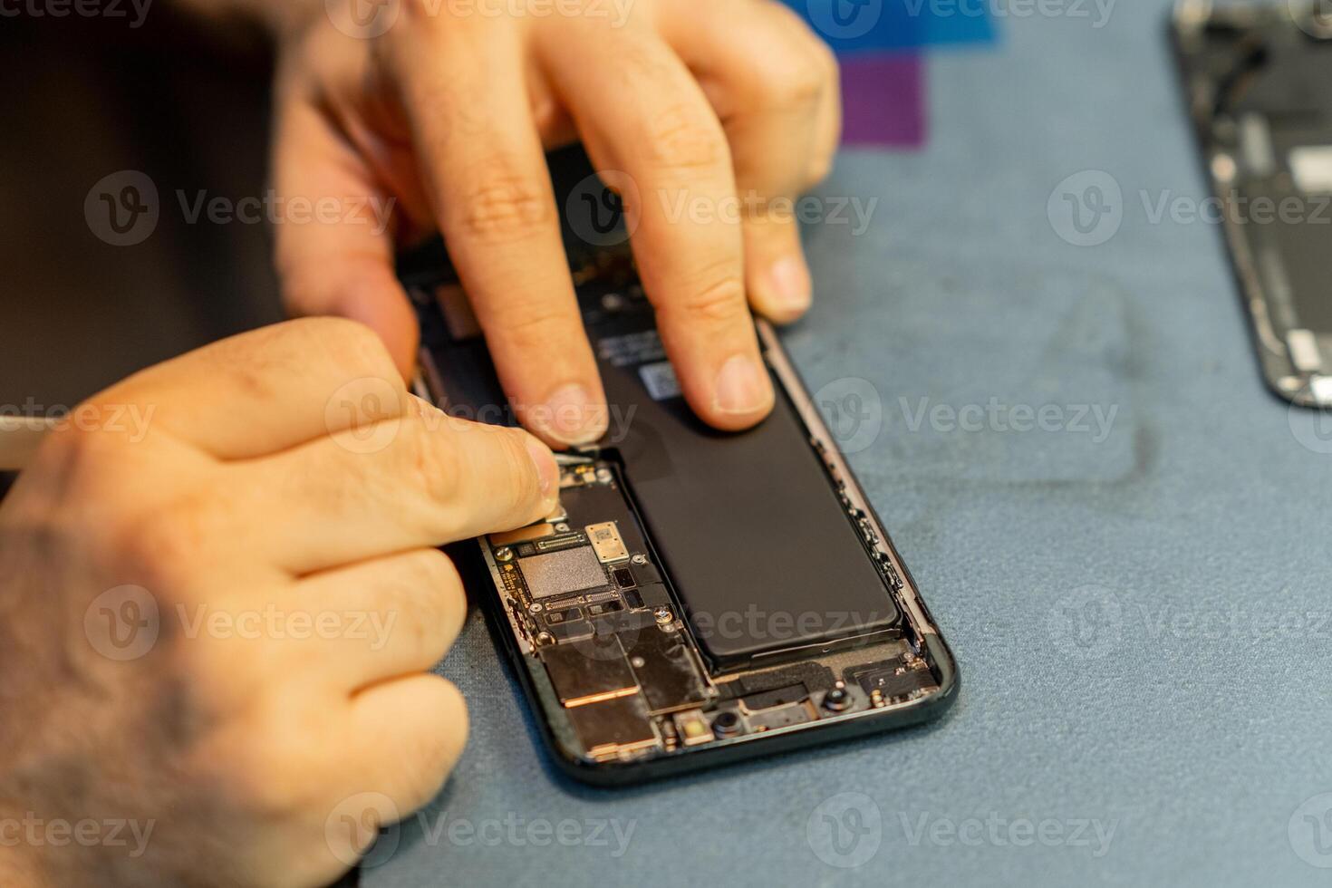 Phone Repair Technician Fixing a Smartphones Internal Components in a Workshop photo