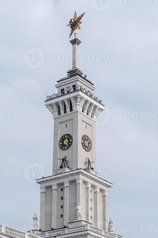 Historical Clock Tower With Golden Star and Intricate Architectural Details Under a Cloudy Sky photo