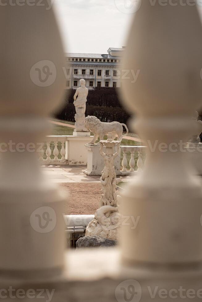 Stunning View of Classical Sculptures in a Historic Garden Framed by Ornate Pillars During Daylight photo