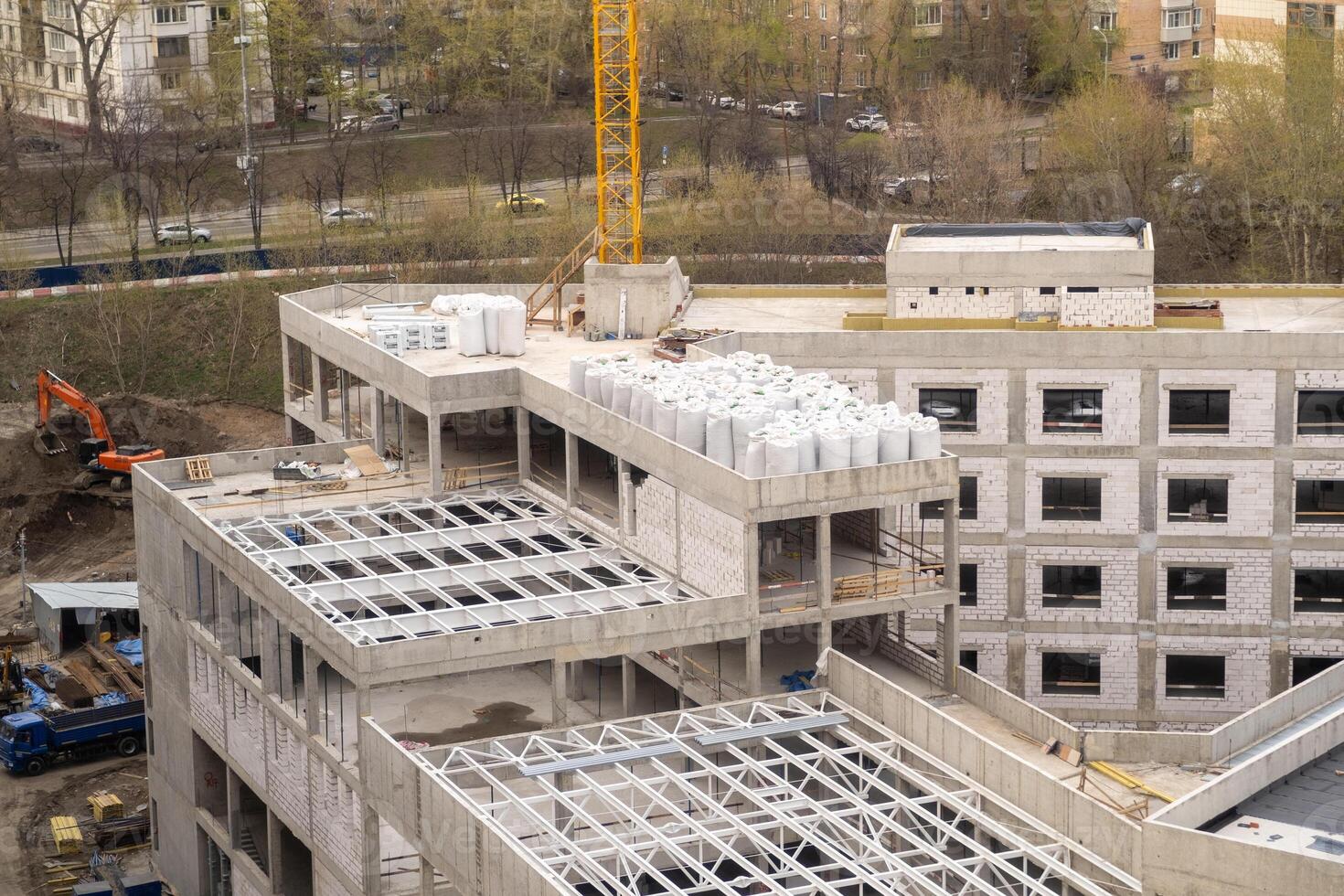 Construction Site Showcasing Progress on a Multi-Story Building With Cranes and Materials Present in an Urban Landscape During Daytime photo