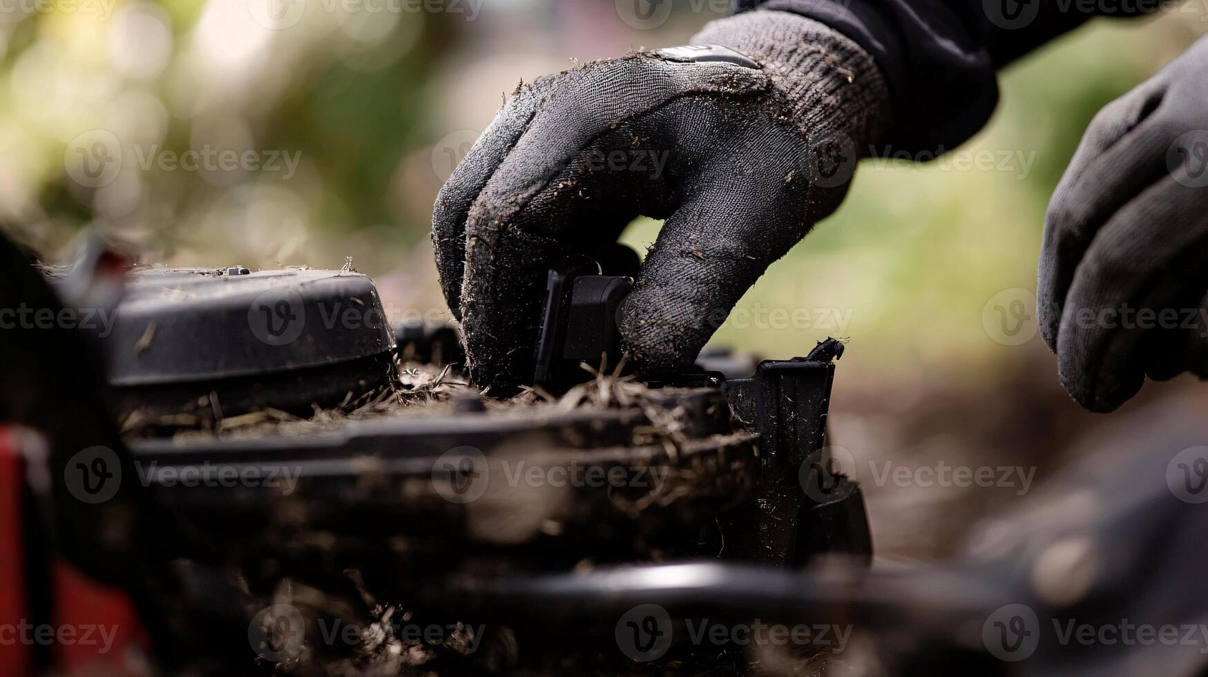 Extreme Close-Up of a Gloved Hand Perfectly Adjusting the Height of a Push Mower photo