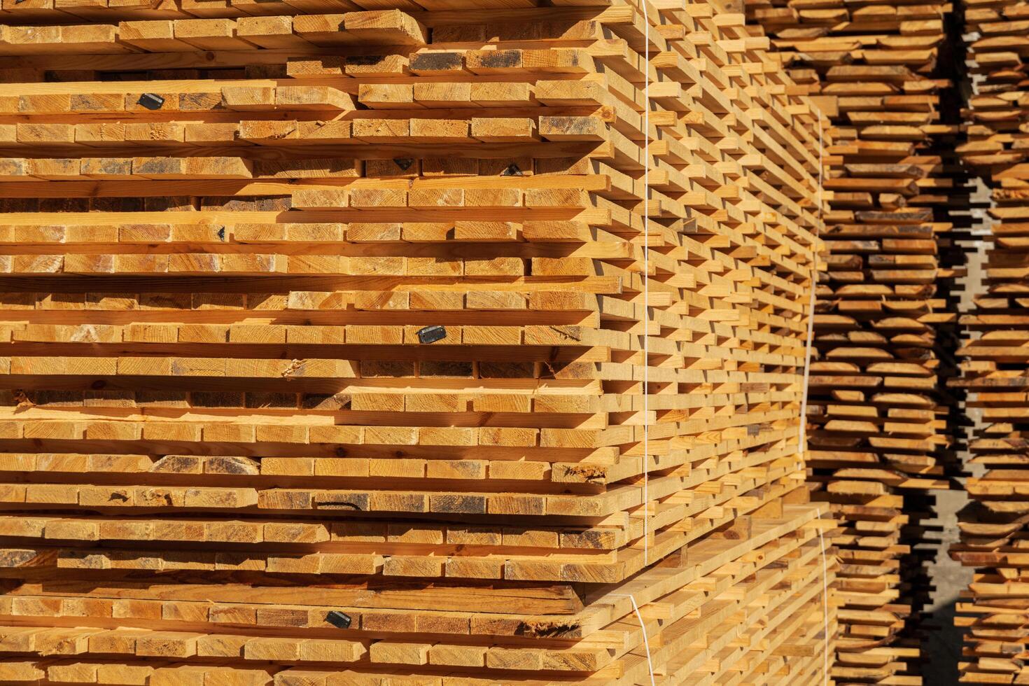 A stack of boards. The boards are stacked on the sawmill. Sawing boards on a sawmill. Production of wood material photo