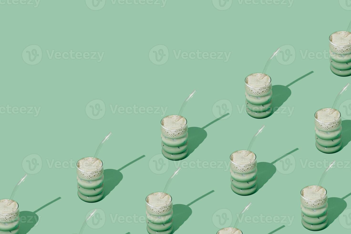 Creative summer pattern made of iced matcha latte on pastel green background. Minimal healthy matcha latte concept. Trendy drink idea. Copy space. photo