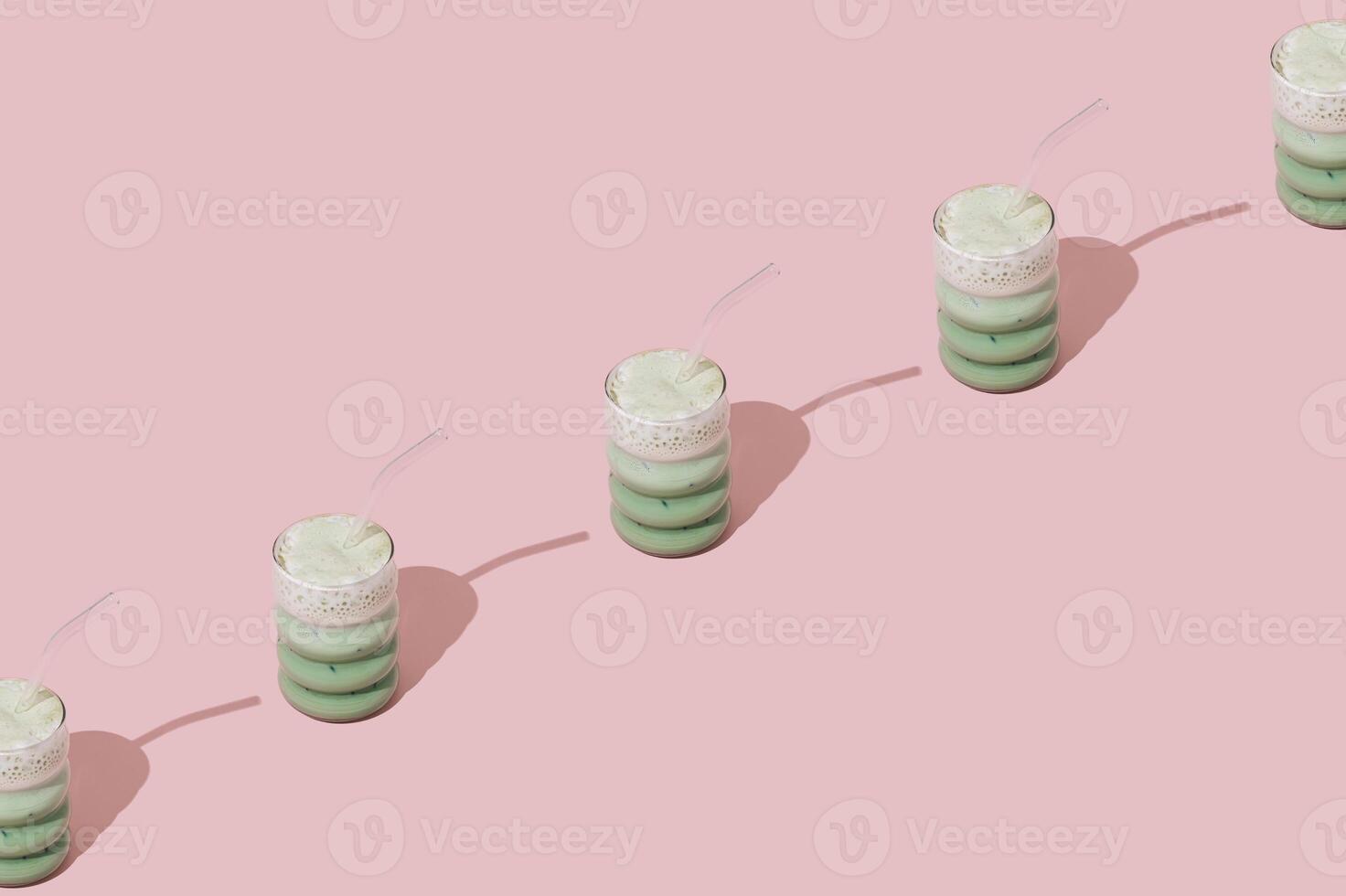 Creative summer pattern made of iced matcha latte on pastel pink background. Minimal healthy matcha latte concept. Trendy drink idea. Copy space. photo