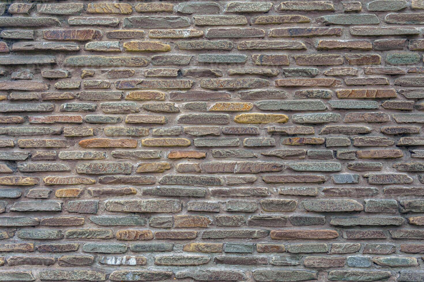 The wall of the castle is made of uneven, flat stones of various dark shades. Abstract dramatic background. photo