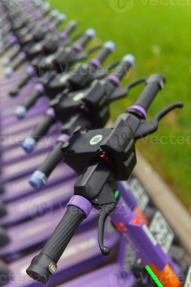 Electric scooters stand in a row. City individual transport. photo