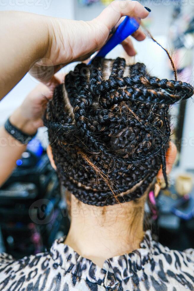 A woman with a braided hair combing her hair photo