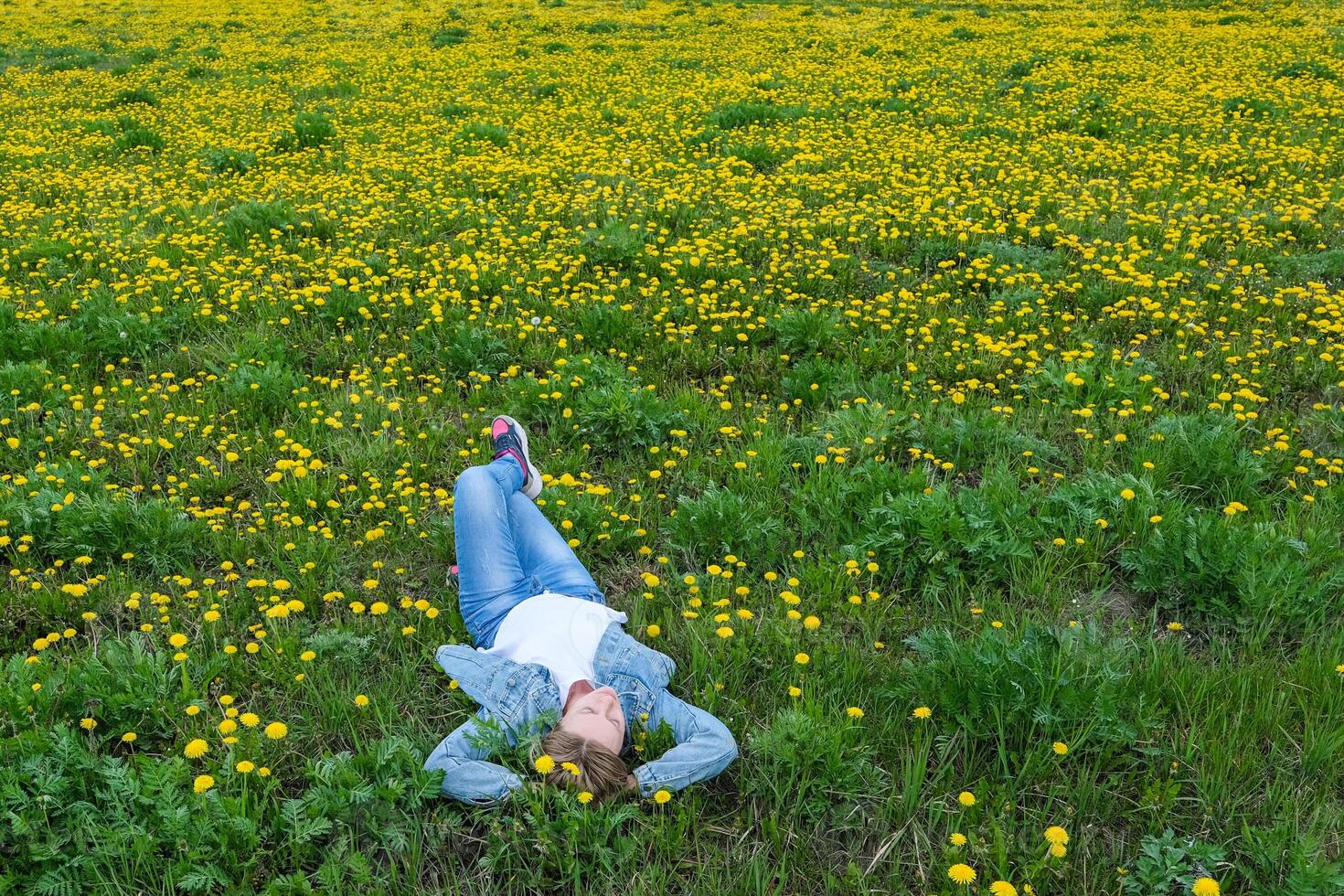 Women in the field with blooming dandelions in natural park photo