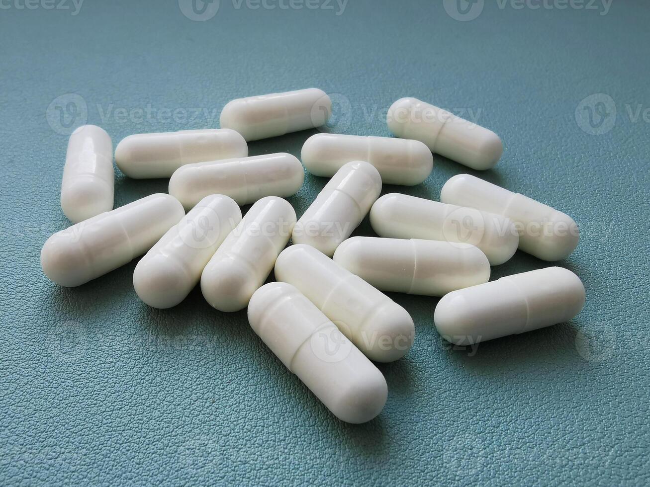 White medical pills on green background with space photo