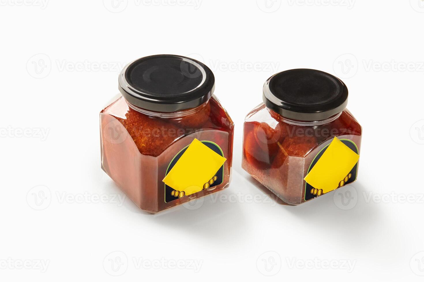 Two jars of baba al rhum showing preserved cherries in rum syrup on white background photo