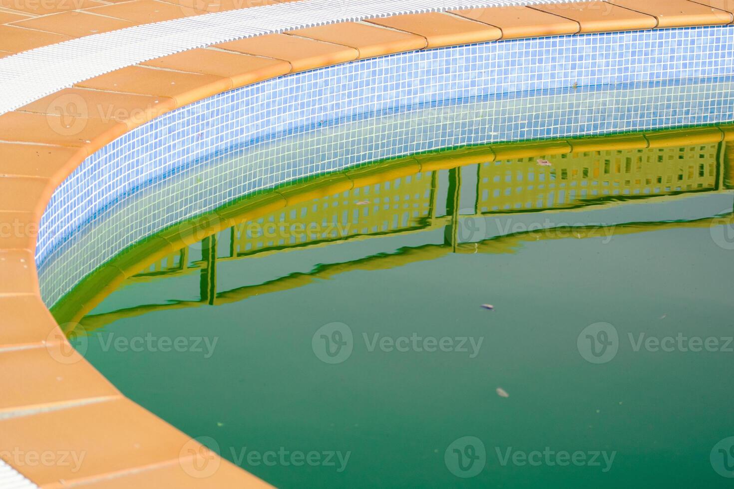 Reflection on the Surface of Stagnant, Dirty Pool Water. Abandoned Swimming Pool with Green Water. photo