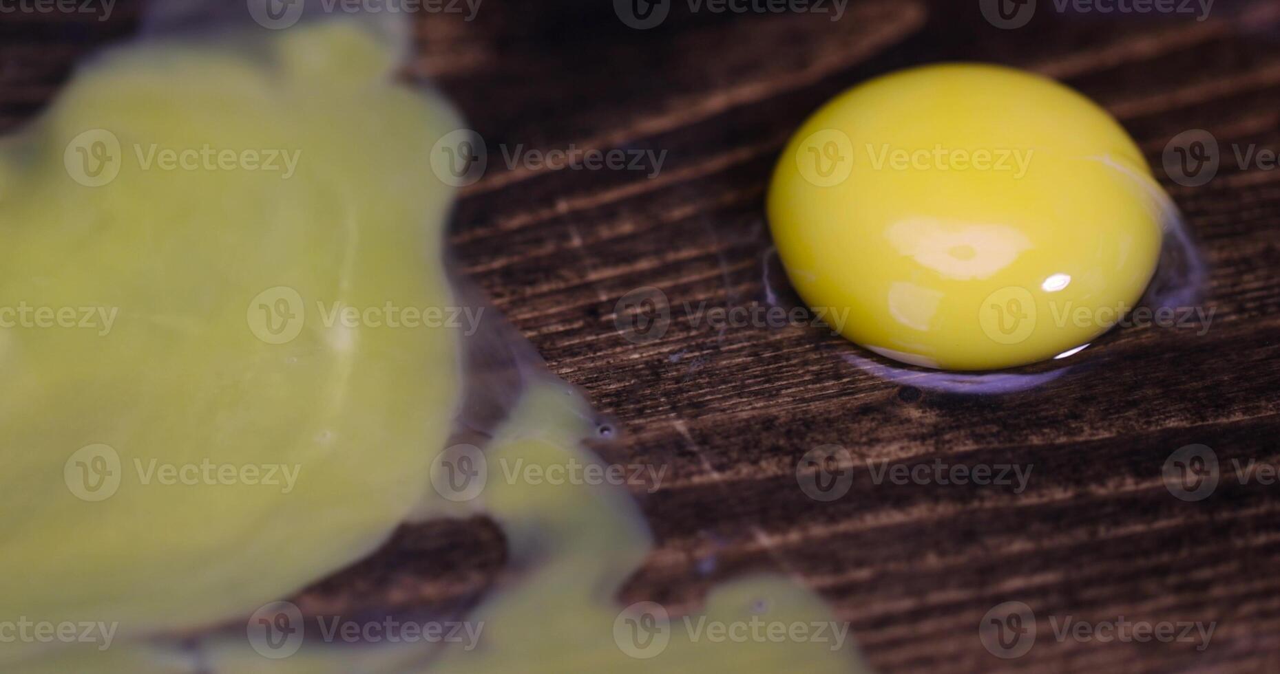 A yellow egg is sitting on top of a wooden surface photo