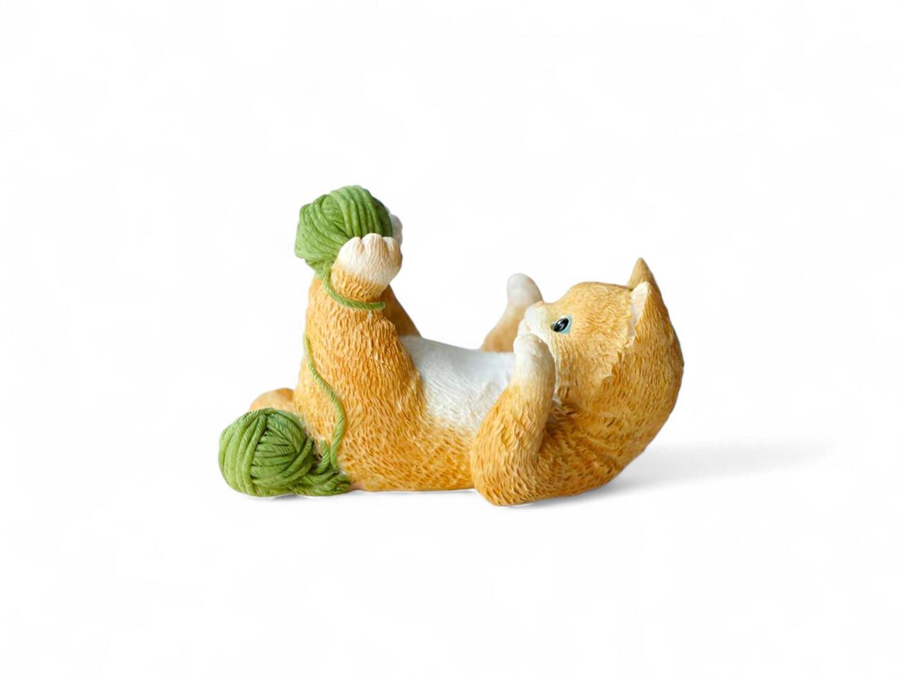 A small figurine of a cat playing with a ball photo