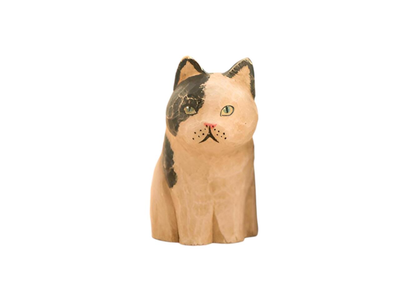 A wooden cat figurine with a black and white face photo