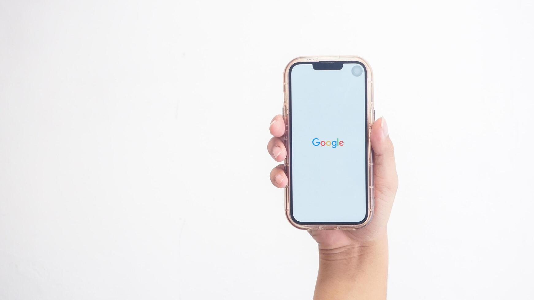 Yogyakarta, Indonesia, 2025 - Hand holdingHand holding smartphone that shows opening page of Google application, a search engine platform, on screen isolated on white background photo