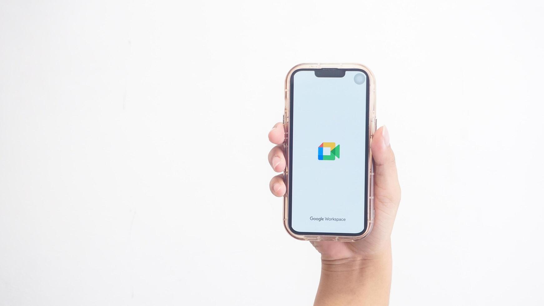Yogyakarta, Indonesia, 2025 - Hand holdingHand holding smartphone that shows front page of Google Meet application on screen isolated on white background photo
