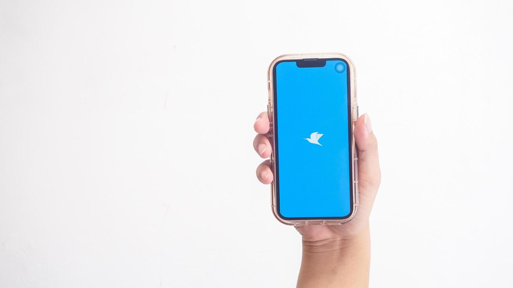 Yogyakarta, Indonesia, 2025 - Hand holding phone that shows Traveloka application icon, online travel agency platform, on the screen isolated on white background photo