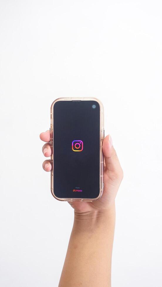 Yogyakarta, Indonesia, 2025 - Hand holdingHand holding smartphone that shows opening page of Instagram platform application on screen isolated on white background photo