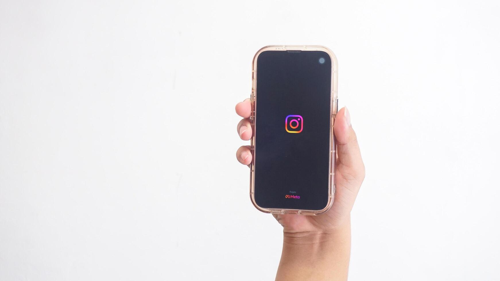 Yogyakarta, Indonesia, 2025 - Hand holdingHand holding smartphone that shows Instagram platform application icon on screen isolated on white background photo