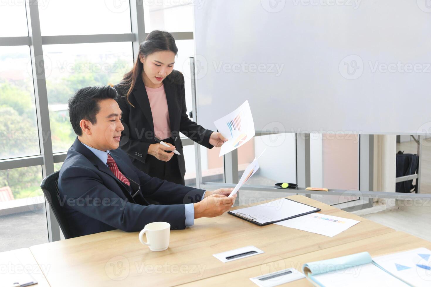 Business Professionals Reviewing Charts in a Modern Office, Colleagues Analyzing Data in a Boardroom, Asian Businesspeople Discussing Financial Reports photo