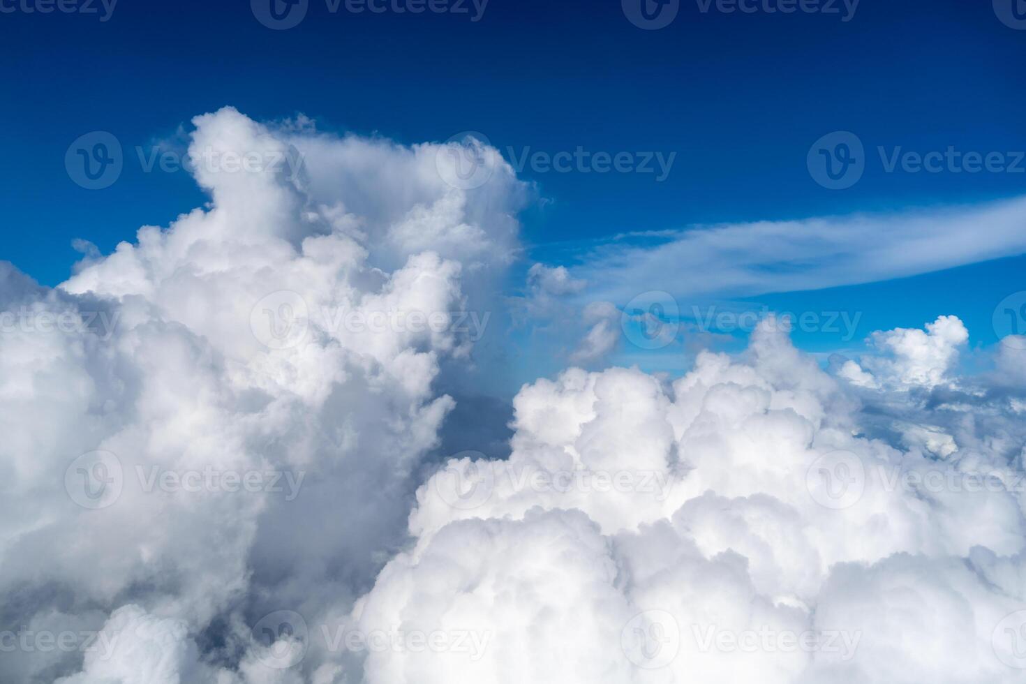 Majestic white clouds and deep blue sky seen from an airplane photo