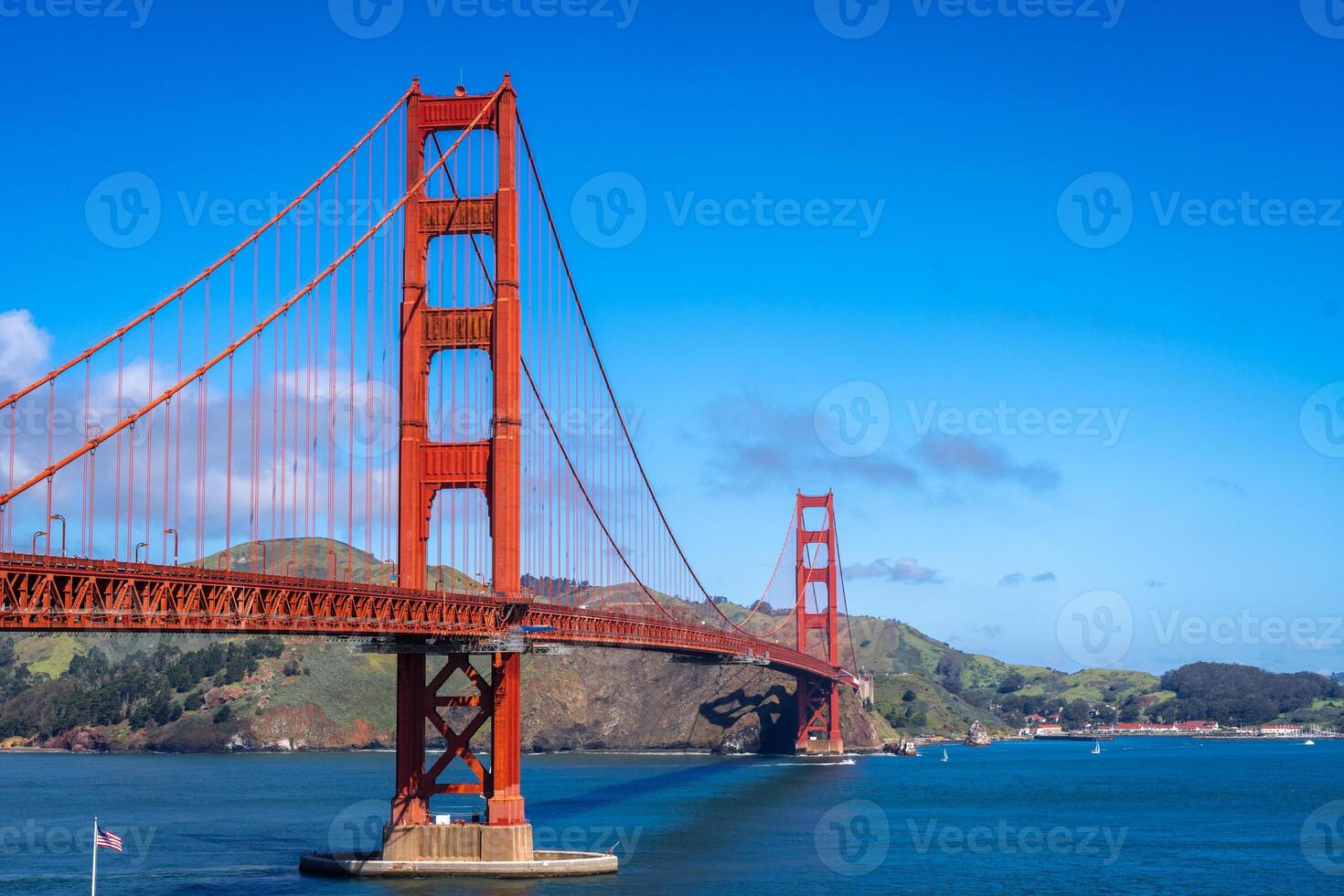 The Golden Gate Bridge over blue waters with scenic hills in San Francisco photo