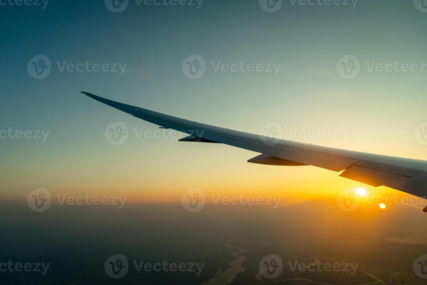 Airplane wing above Osaka coast during sunset descent flight photo