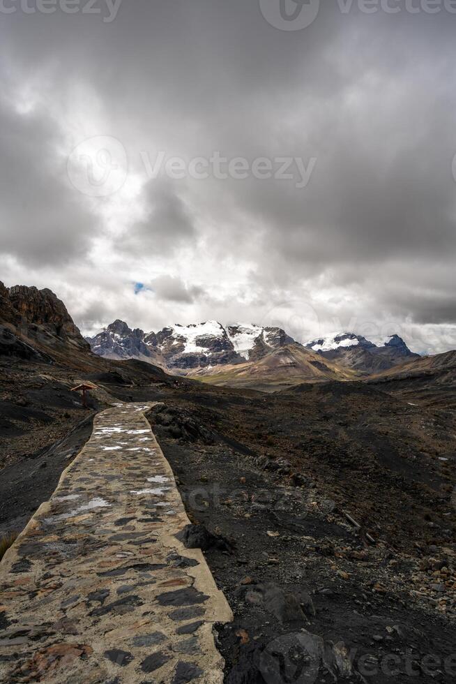 Stone trail, leading to Pastoruri Glacier, Huaraz, Peru, amidst rugged mountains photo