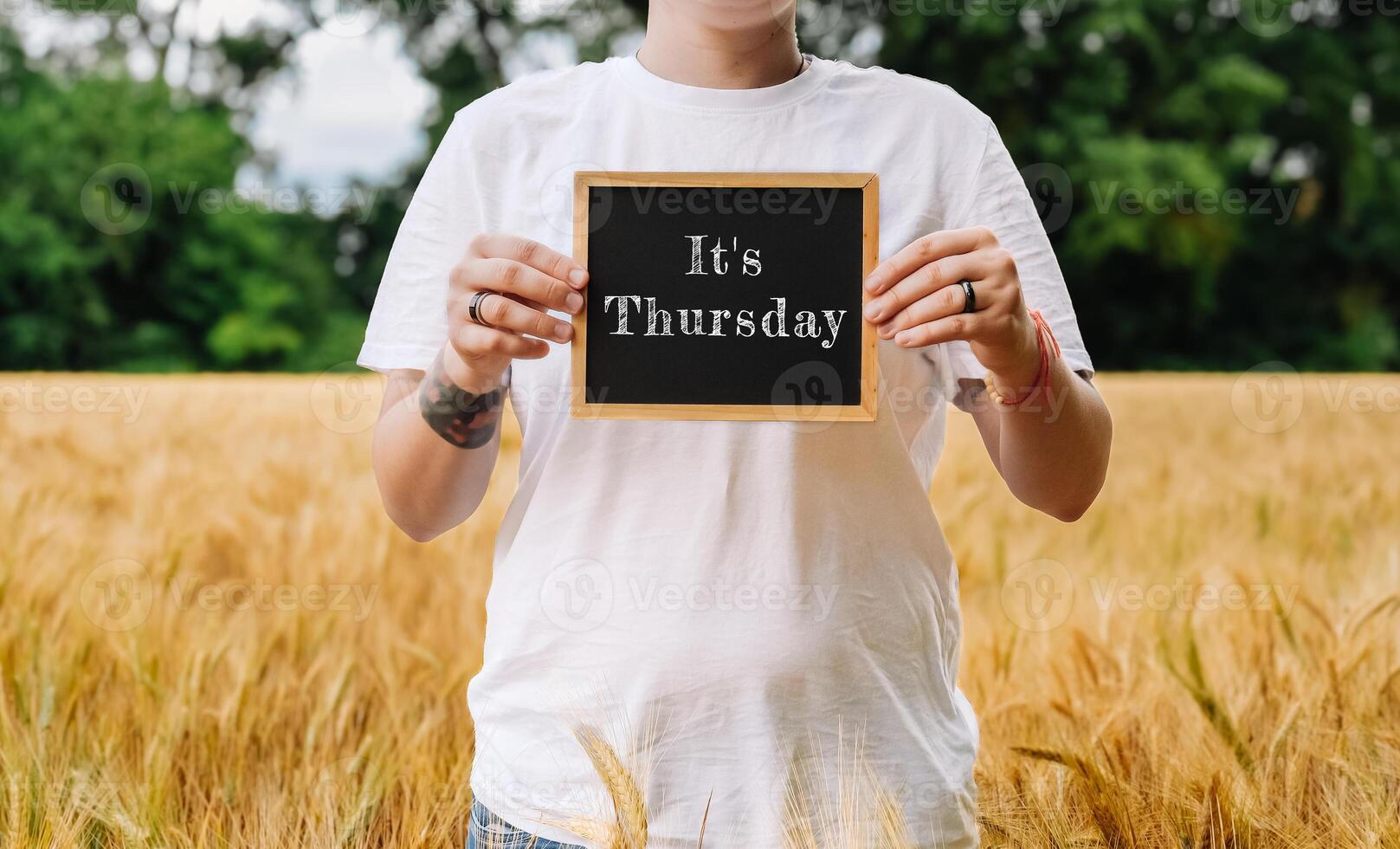Man holding a chalkboard with the words Its Thursday written on it photo