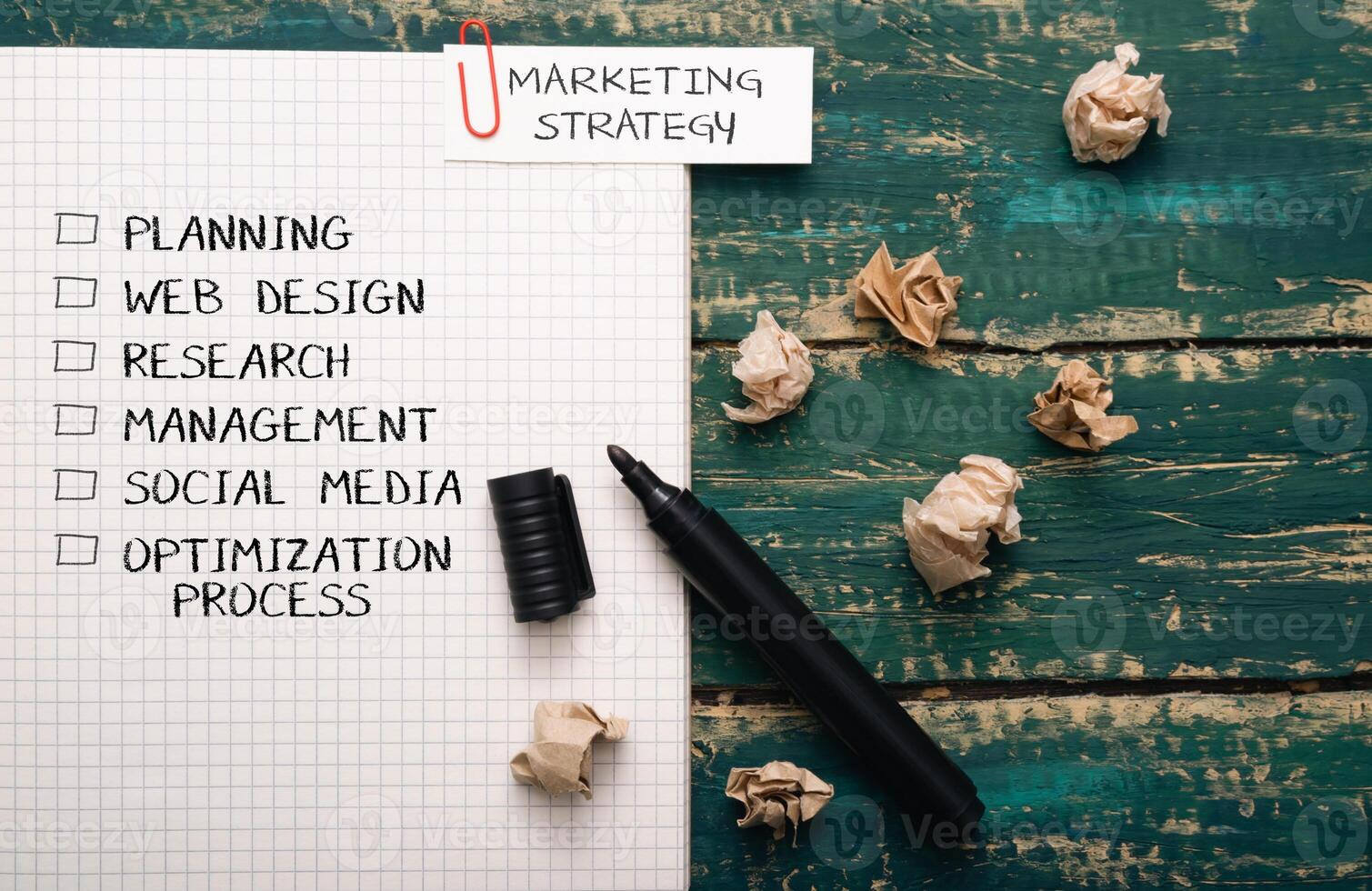 Black marker sits on a piece of paper with a list of marketing strategies photo