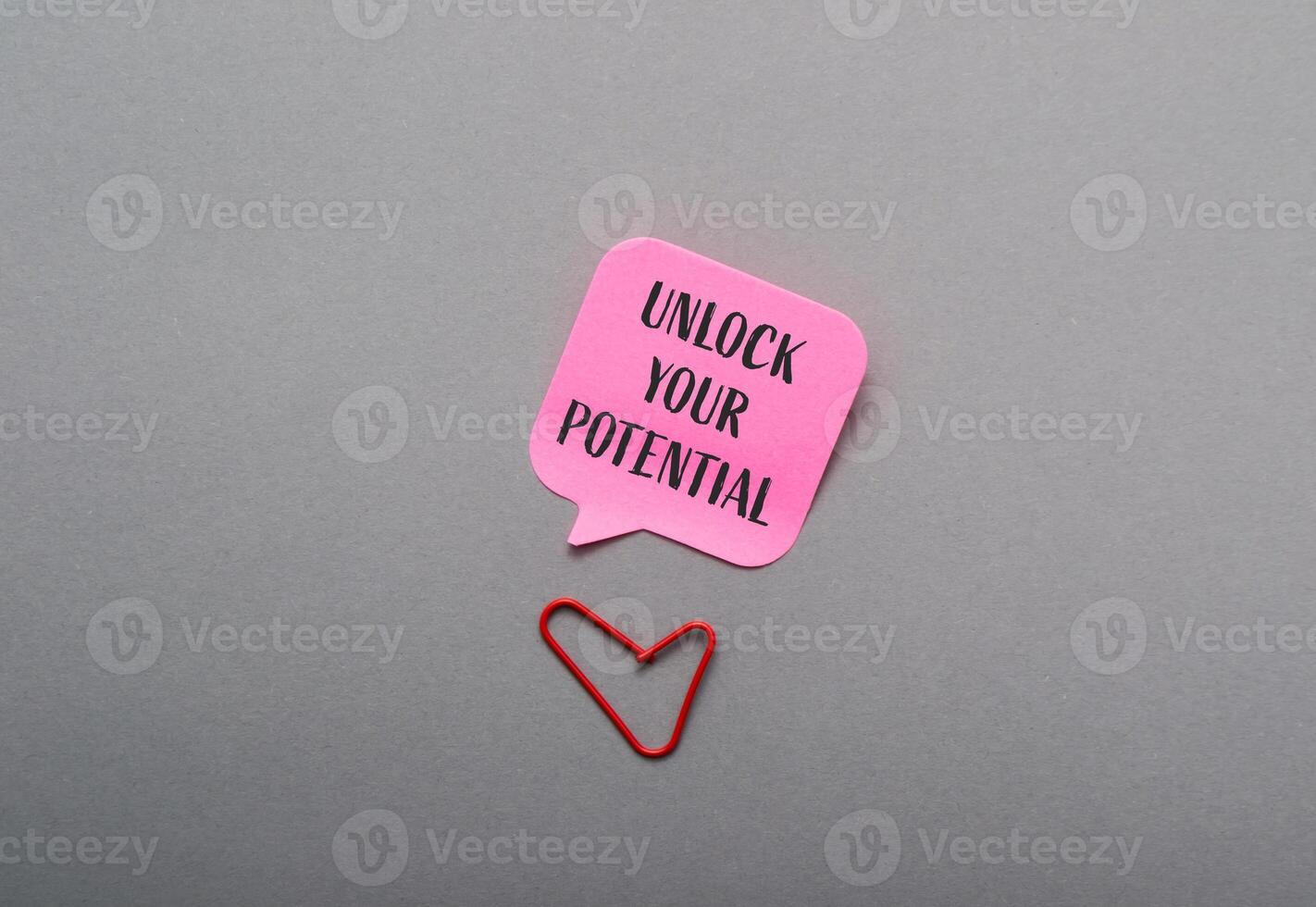 Pink sticky note with the words Unlock Your Potential written on it photo