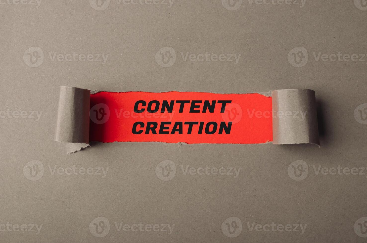 Words Content Creation on red view through torn paper photo