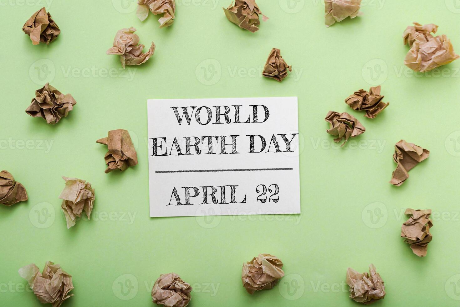 Green background with a piece of paper that says World Earth Day on it photo