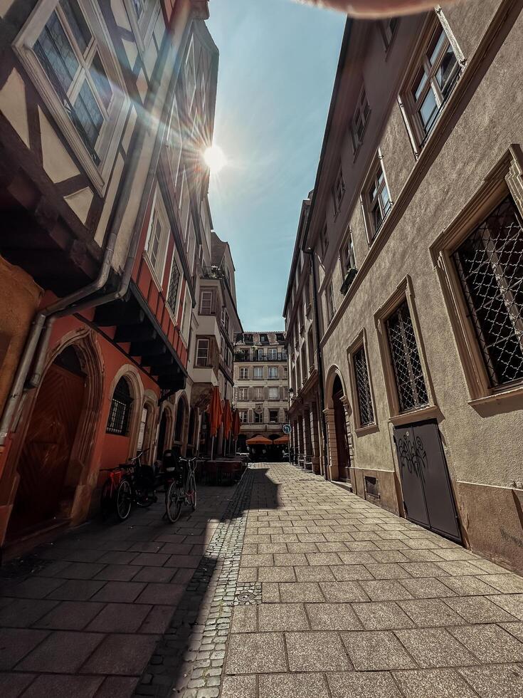 Strasbourg France - July 26, 2024 - Narrow alleyway with a few shops and a few bicycles photo
