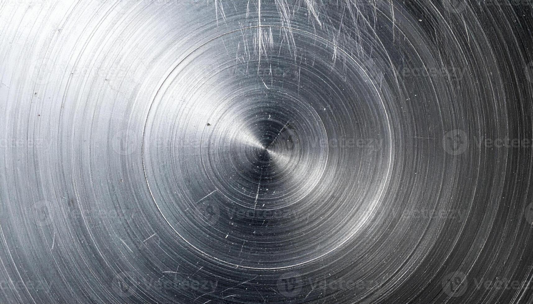 circular brushed metal surface with scratch marks and realistic concentric grinding texture, industrial background photo