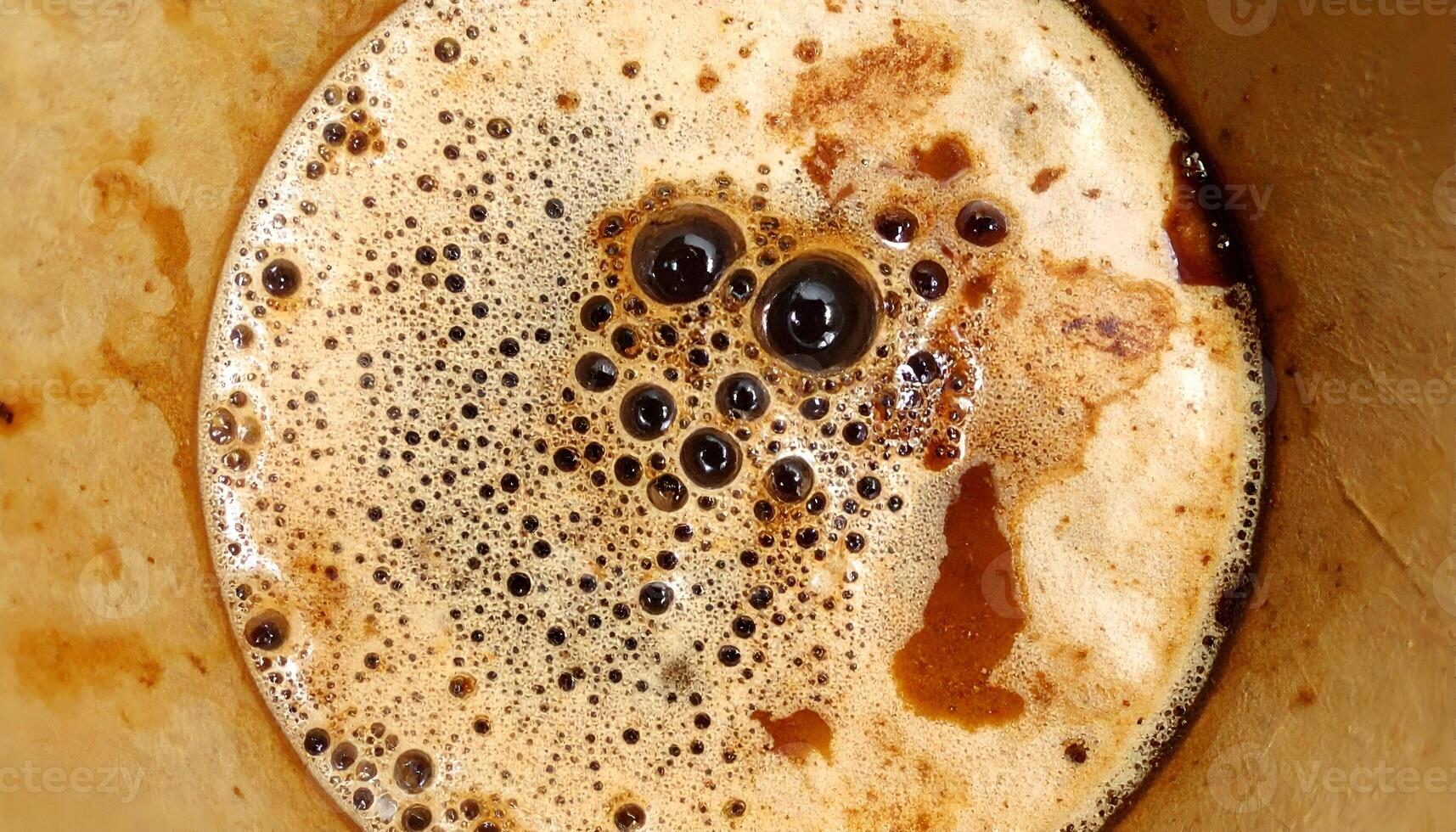 top view of stained coffee filter with bubbly crema and dark roast residue, textured caffeine foam background for coffee design and beverage art photo