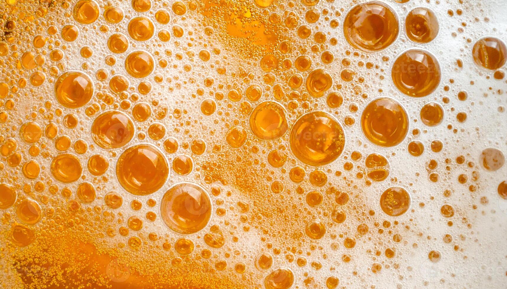 closeup macro texture of frothy golden beer surface with bubbles and foam abstract pattern for background use photo
