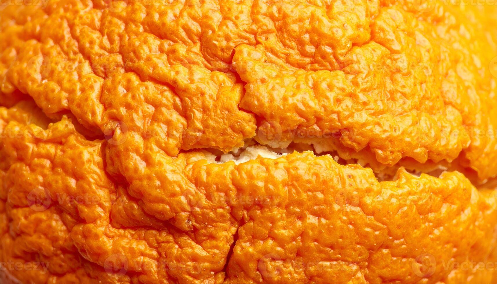 extreme macro of cracked and dried orange peel surface with rough wrinkled skin texture, detailed natural citrus pattern for organic food or abstract background photo