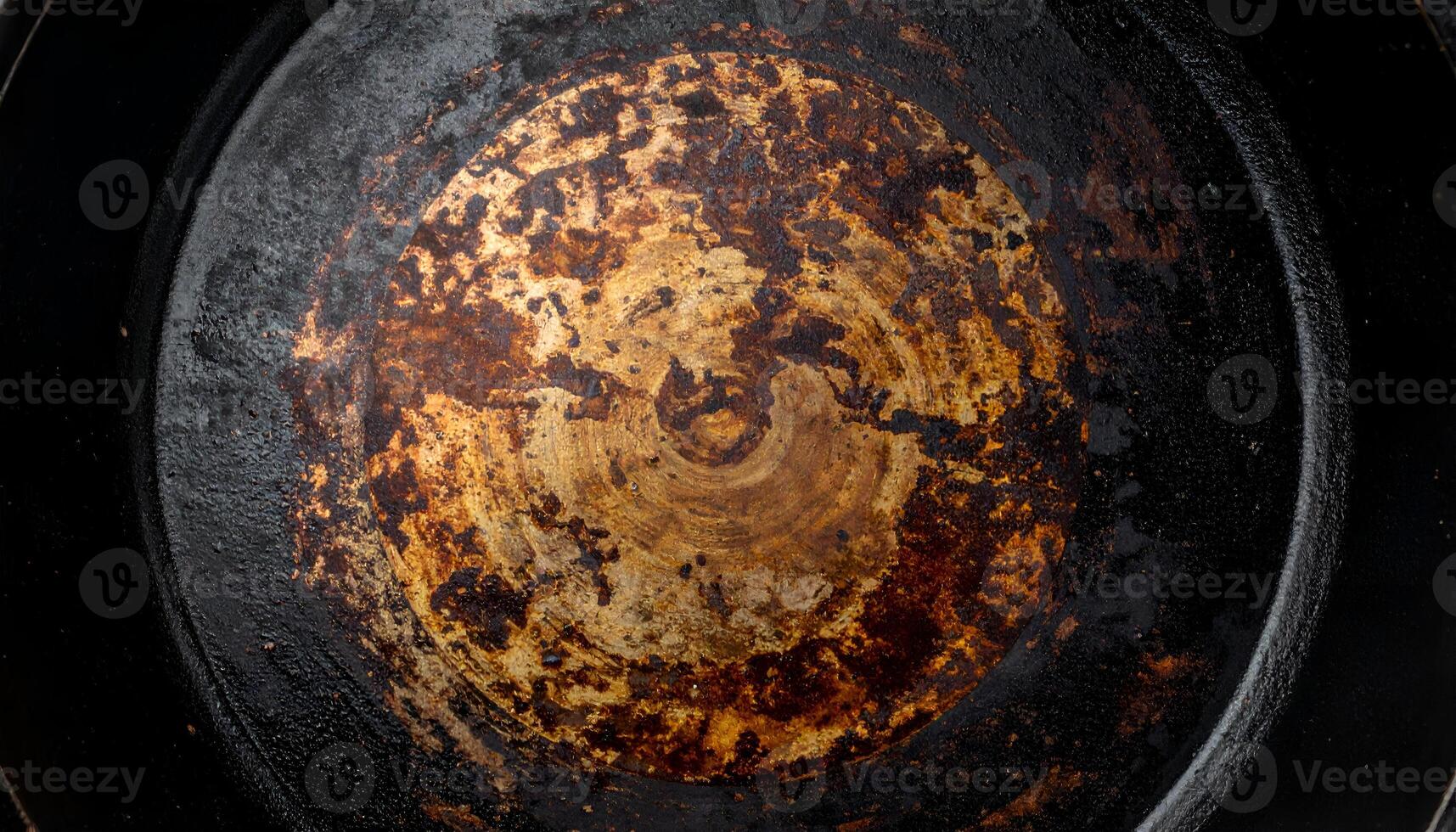 seasoned and burnt cast iron pan surface with circular grunge pattern, rustic cooking texture for culinary design, food background and abstract art overlays photo