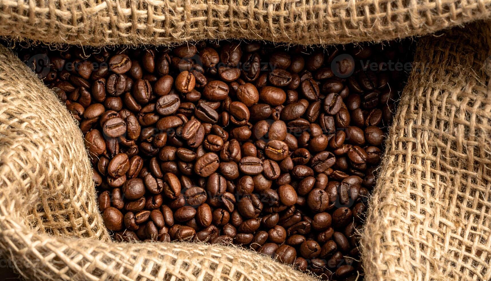 roasted coffee beans in natural jute sack, top view of organic coffee packaging with rustic texture for cafe branding and sustainable product design photo