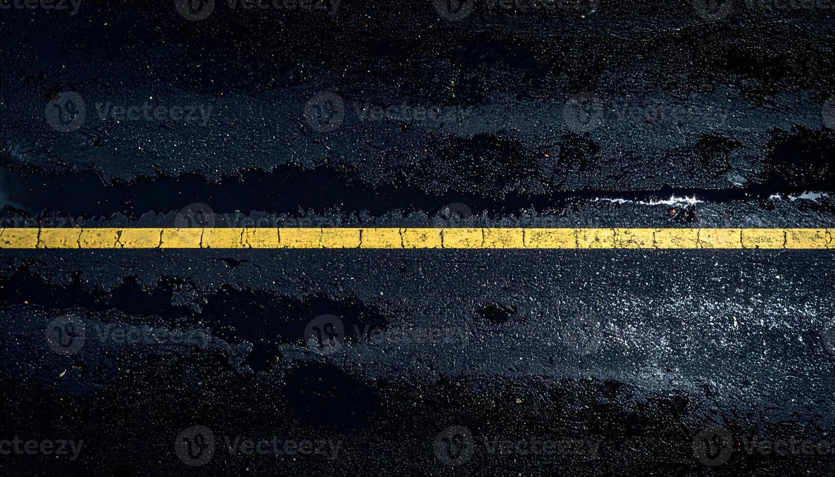 wet asphalt street texture at night with single yellow line, rainy road surface close-up with moody lighting and dark urban background photo